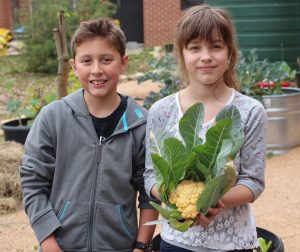 photo of two students, one holding cauliflower